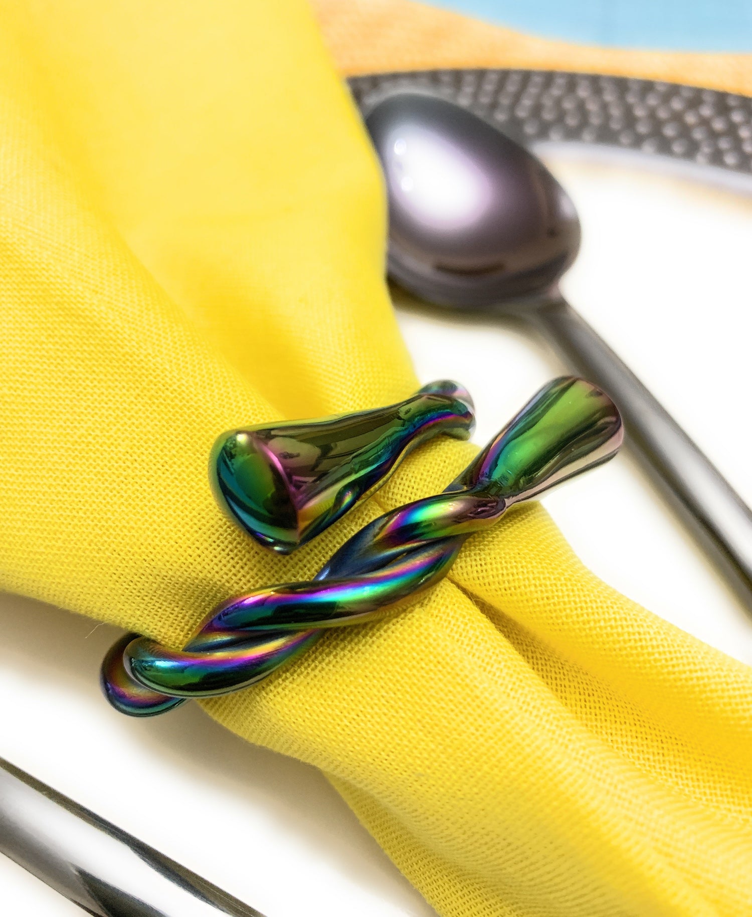 Set of four rainbow-colored Vibhsa Modern Napkin Rings by Gold Juniper, dishwasher safe for stylish table setting.