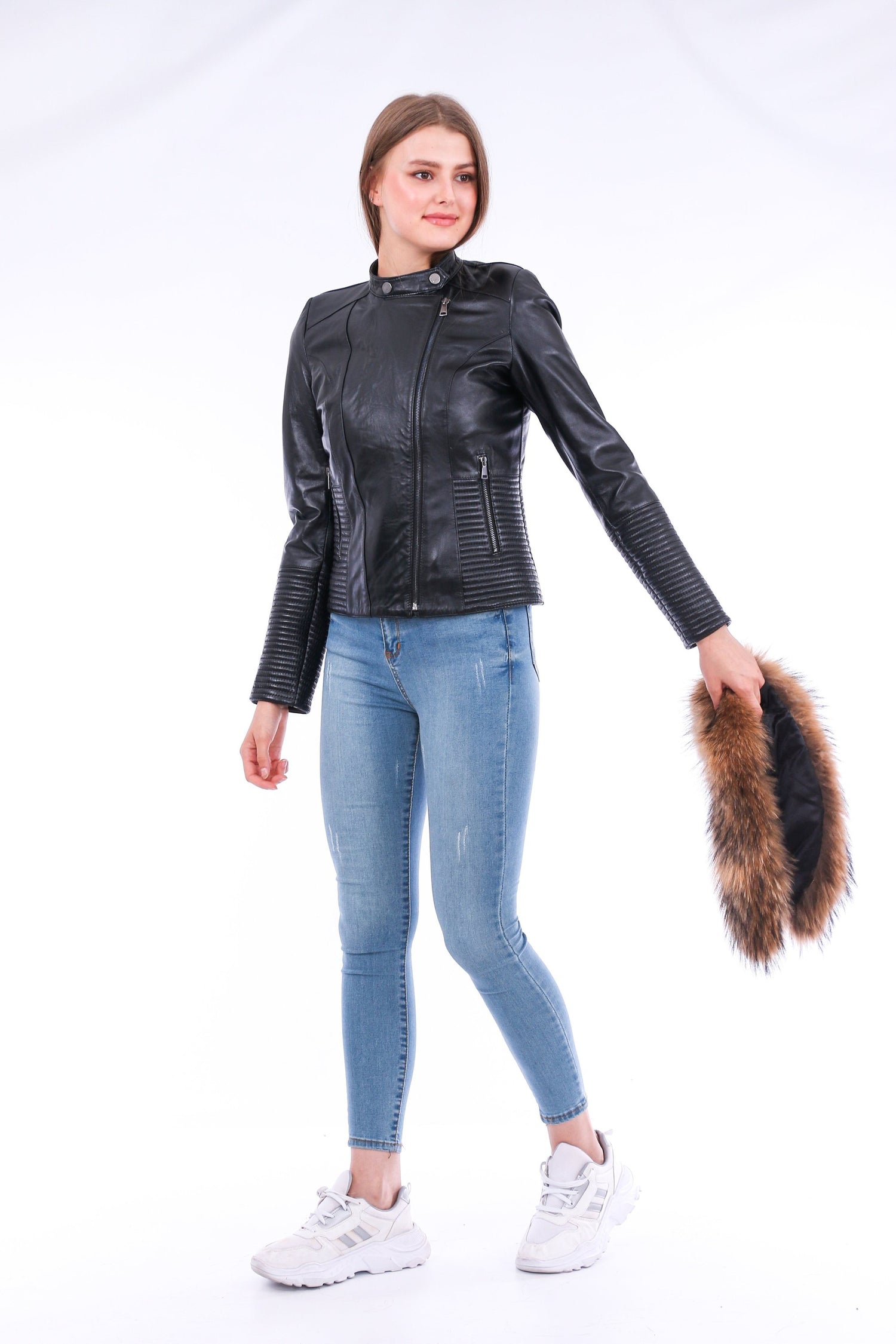 Black Ravenna leather biker jacket by Sangria Iapetus hanging on a wooden hanger. Features classic lapels and silver zipper details.