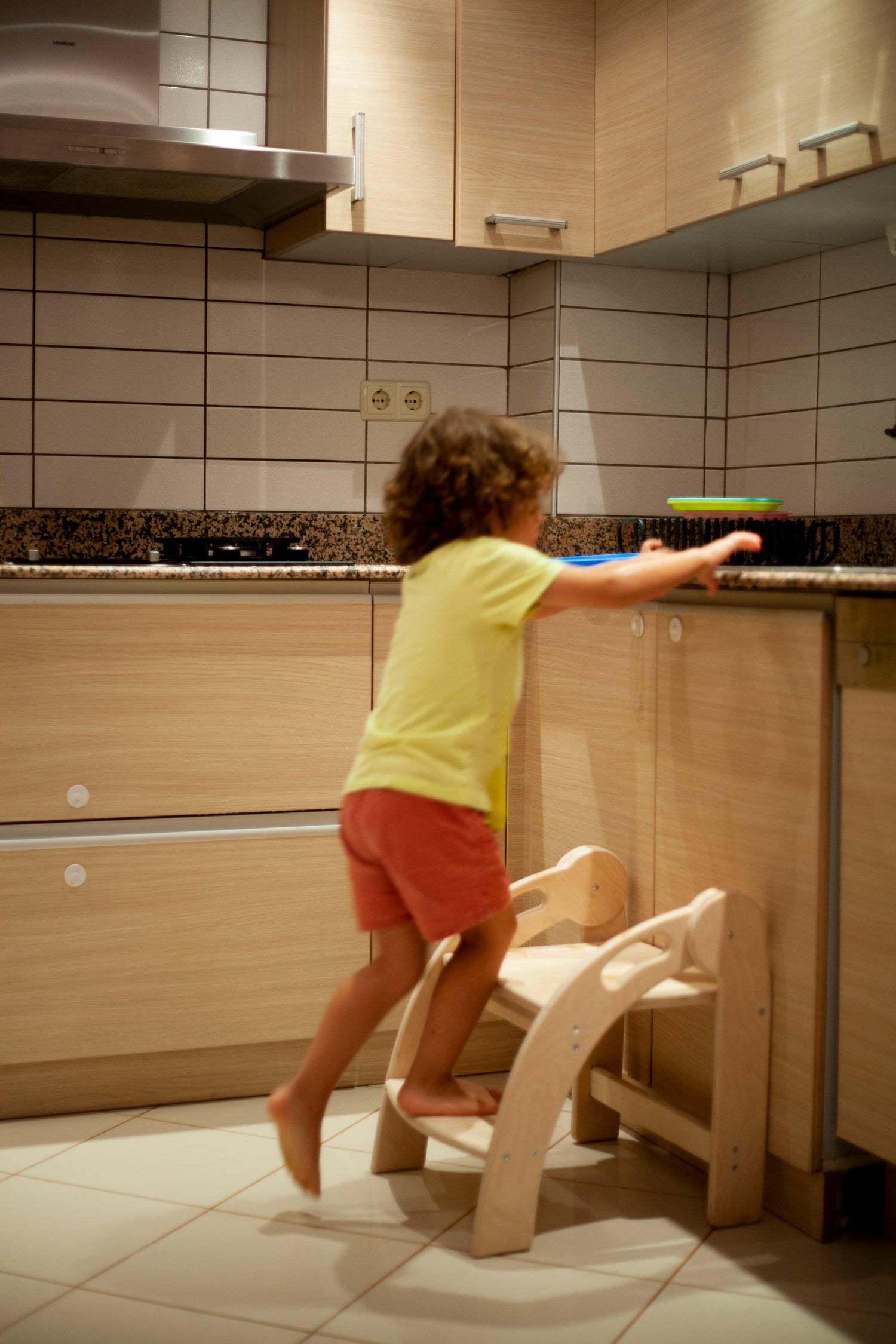 Red Oceanus foldable Montessori kitchen step stool with non-slip surface and sturdy wooden construction for child safety and convenience.