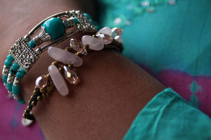 Silver Hestia feather charm and beads bracelet with delicate silver charms and colorful beads, stylish jewelry accessory.