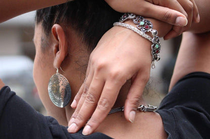 Silver Hestia Grand Om yoga earrings with intricate Om symbols and delicate design, displayed on a white background.