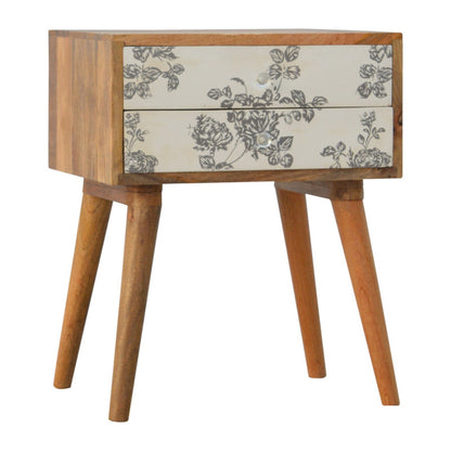 Black floral screen printed bedside table from Jade Epimetheus, showcasing intricate floral patterns and sleek furniture design.
