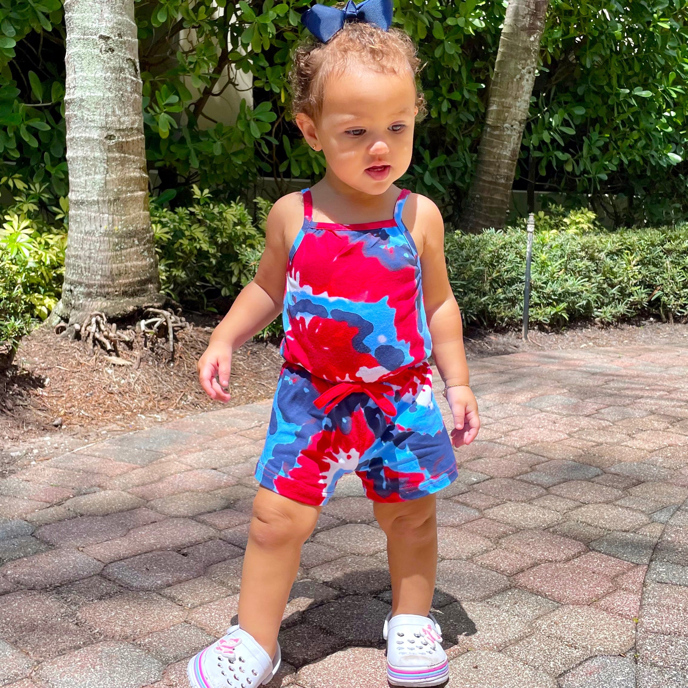 Black Simba AnnLoren girls tie-dye 4th of July shorts jumpsuit, summer romper for kids, featuring patriotic red, white, and blue design.