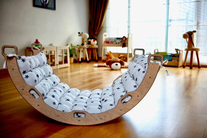 Red Oceanus climbing arch with star-patterned pillow for kids, featuring a sturdy wooden rocker and colorful star design.