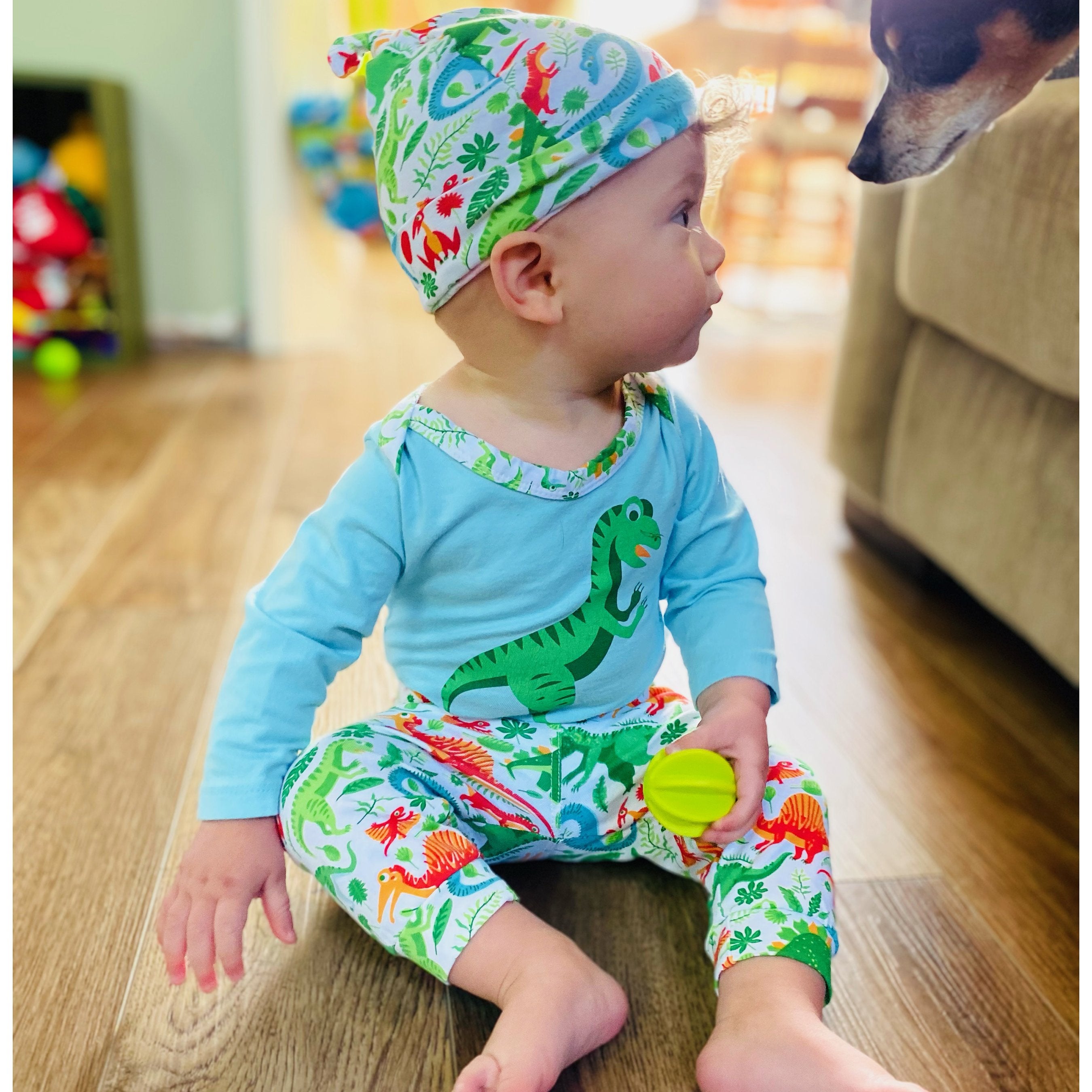 Black Simba AnnLoren baby layette set with dinosaur-themed long sleeve onesie, pants, and cap for boys, featuring cute dinosaur prints.