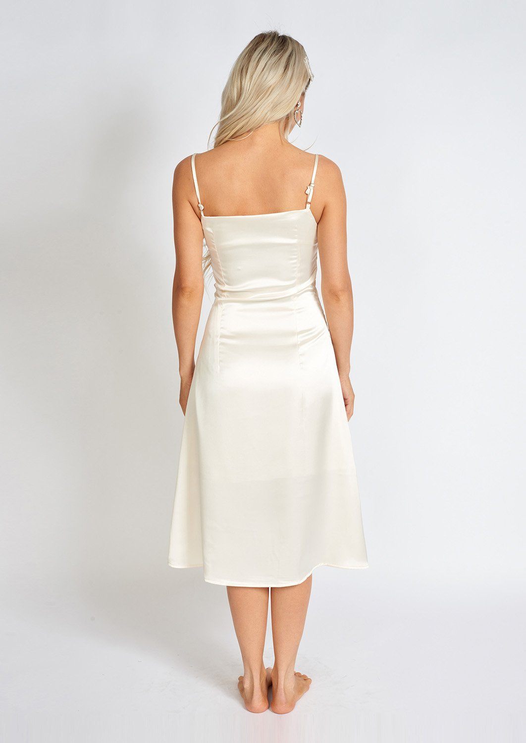 Azure Thanatos Léonie One Pearl Satin Slip Dress hanging on a mannequin, showcasing elegant pearl accents and silky satin fabric.