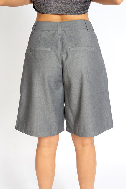 Grey loose cut cloth Bermuda shorts by Azure Thanatos hanging on a rack, showcasing a relaxed fit and casual style.
