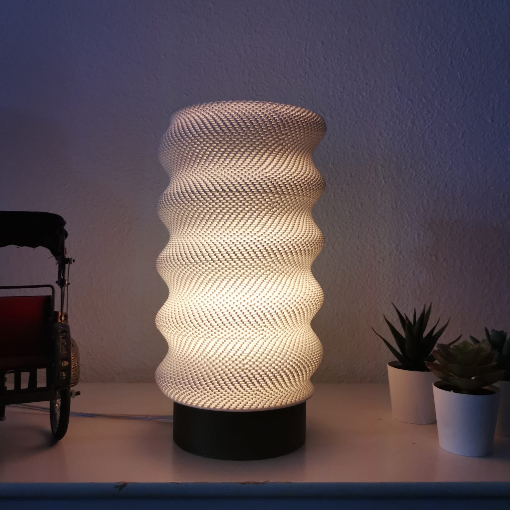Azure Pontus Lumina Twist portable table lamp with a sleek, modern design and adjustable lighting on a wooden surface.