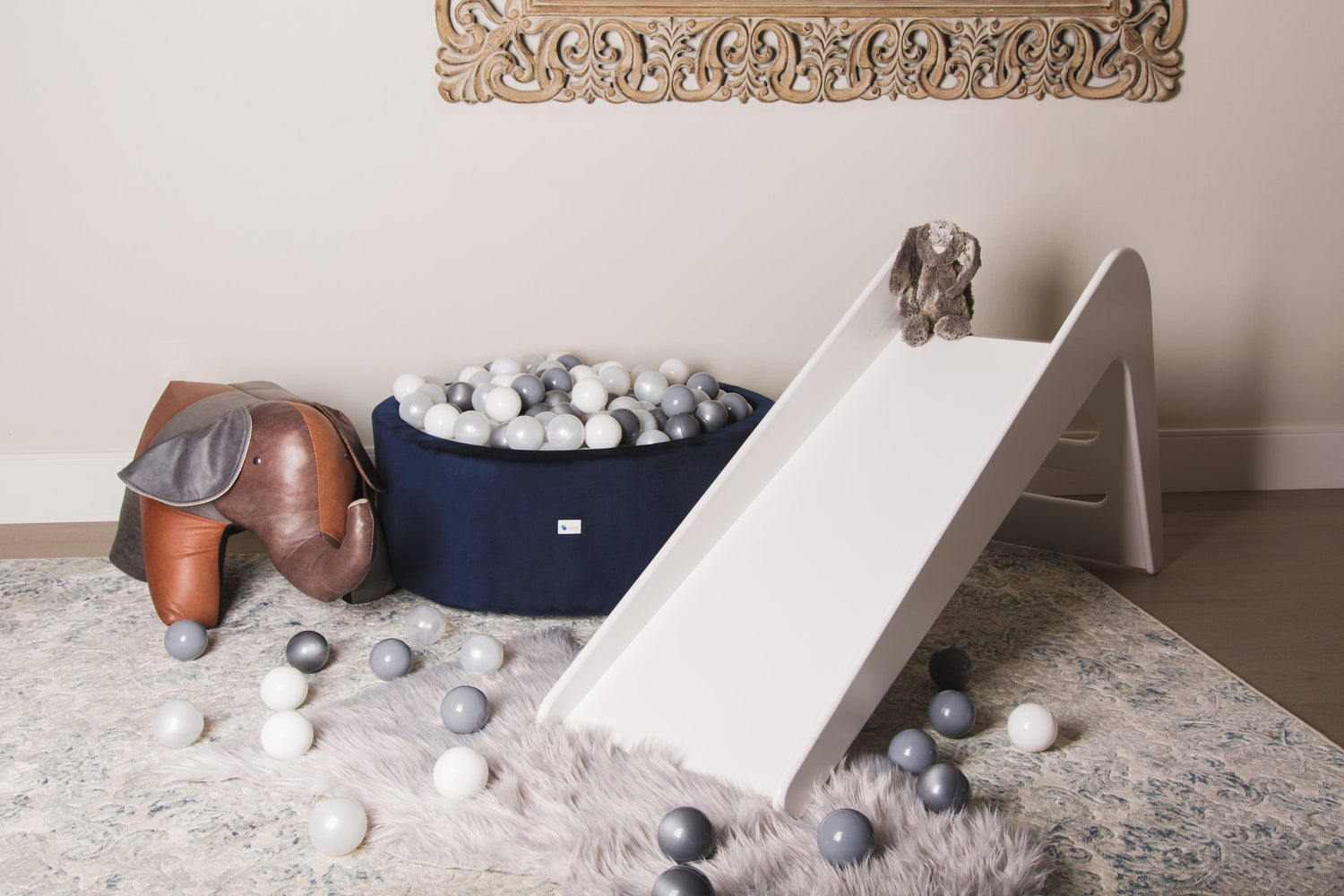 White wooden indoor slide for kids from Rose Metis, featuring a sleek design and smooth finish, ideal for playrooms and nurseries.