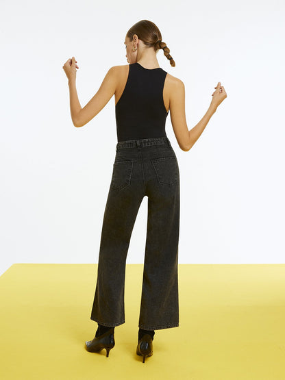 Woman wearing high-waisted ripped jeans by Bronze Aphrodite, showcasing distressed denim style and modern fit.