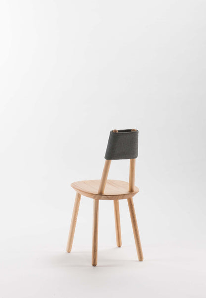 Aquamarine Poppy Naïve Dining Chair with wooden legs and upholstered seat, modern furniture design in a natural setting.