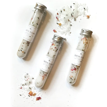 Indigo Poseidon Soothe + Relax Bath Soak with peppermint, eucalyptus, lavender, and rose essential oils in a clear jar.