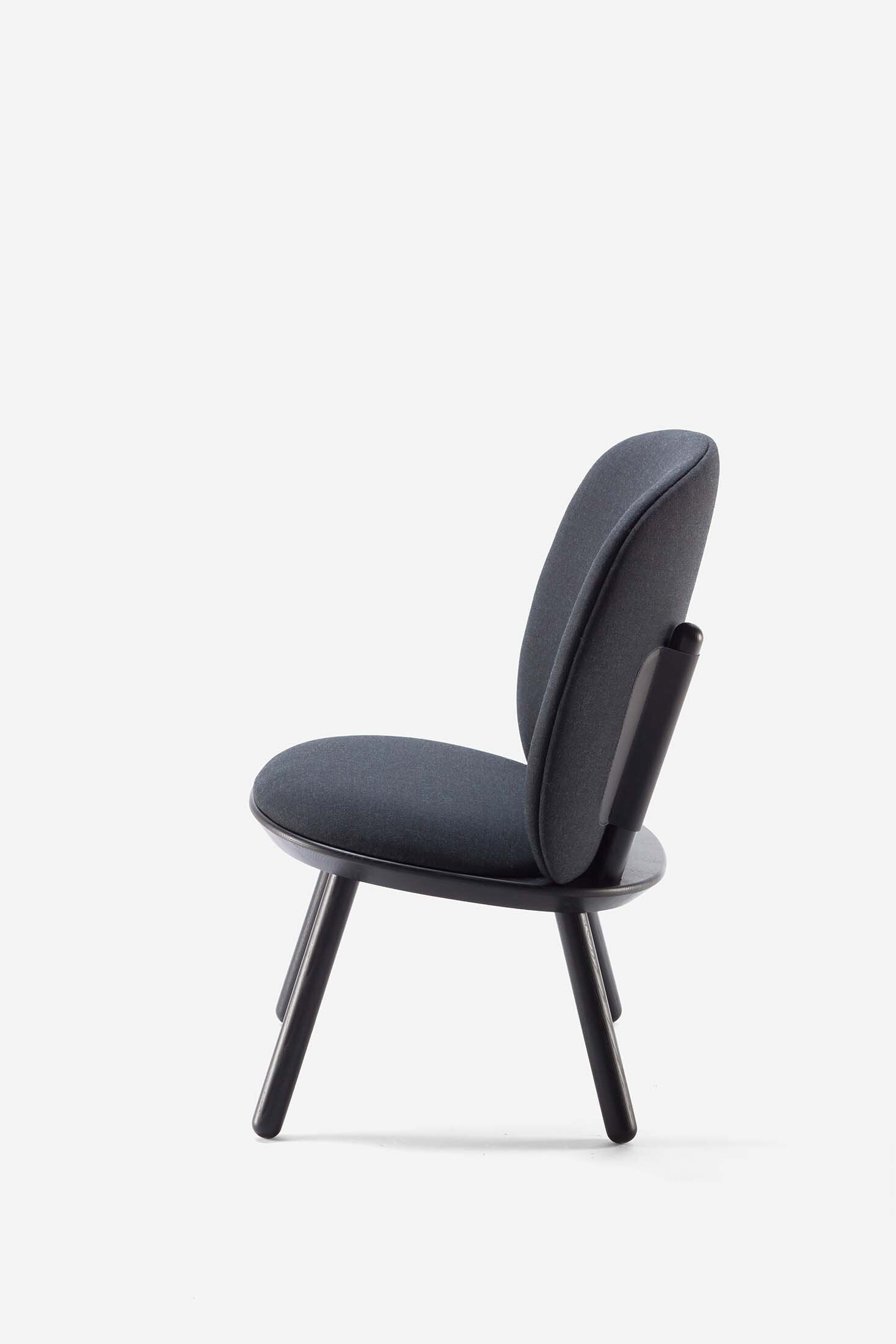 Naïve Low Chair by Aquamarine Poppy in black with a modern, minimalist design, featuring a curved seat and sleek wooden legs.