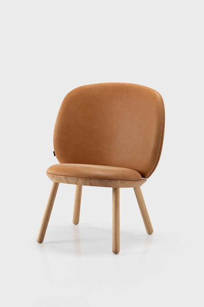 Aquamarine Poppy Naïve Low Chair in cognac leather with wooden legs, modern furniture design, close-up view of the chair.