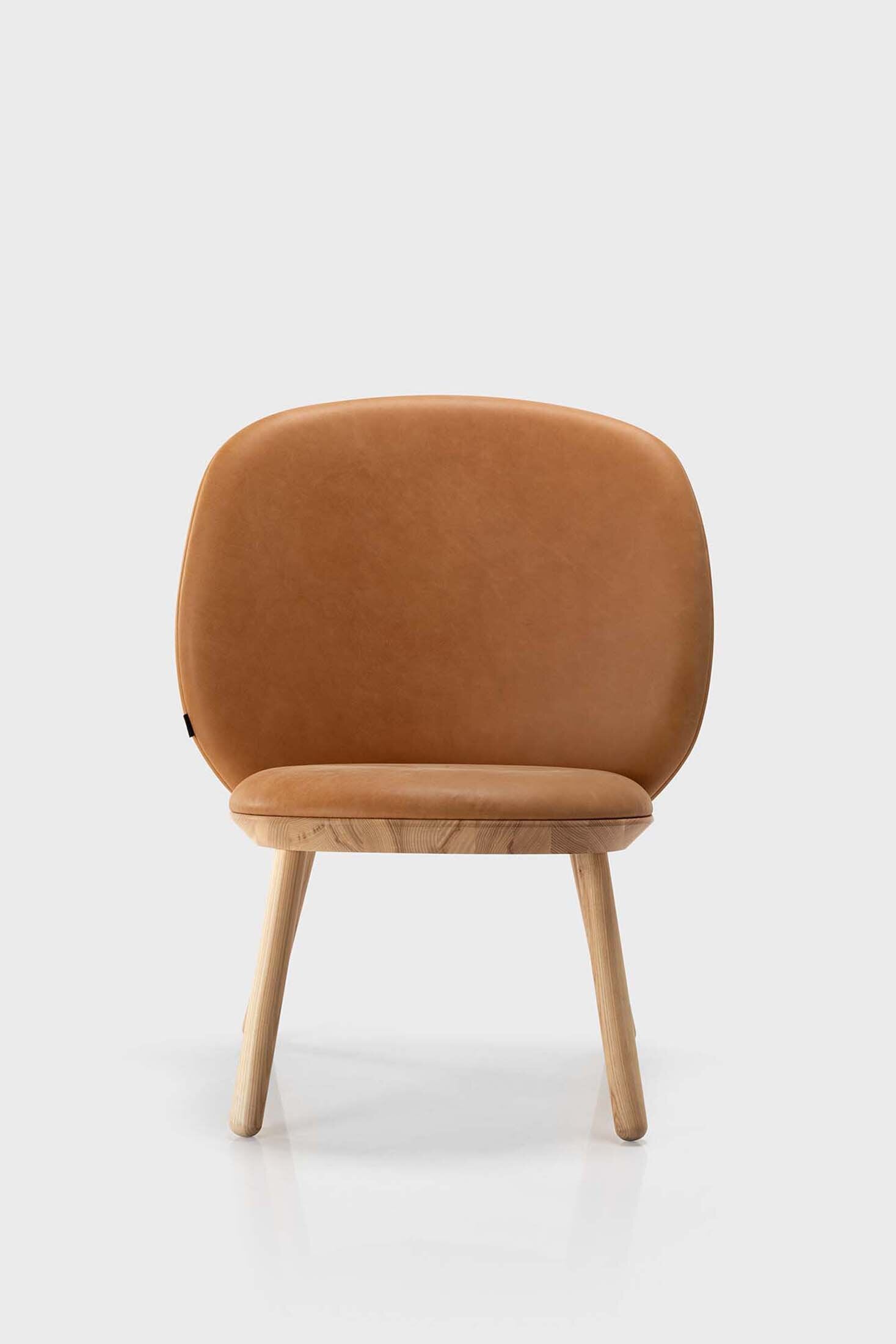 Aquamarine Poppy Naïve Low Chair in cognac leather, showcasing its modern, minimalist furniture design with wooden legs.