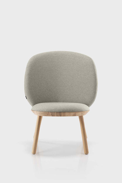 Beige Naïve Low Chair by Aquamarine Poppy featuring a modern, minimalist furniture design with a curved seat and wooden legs.