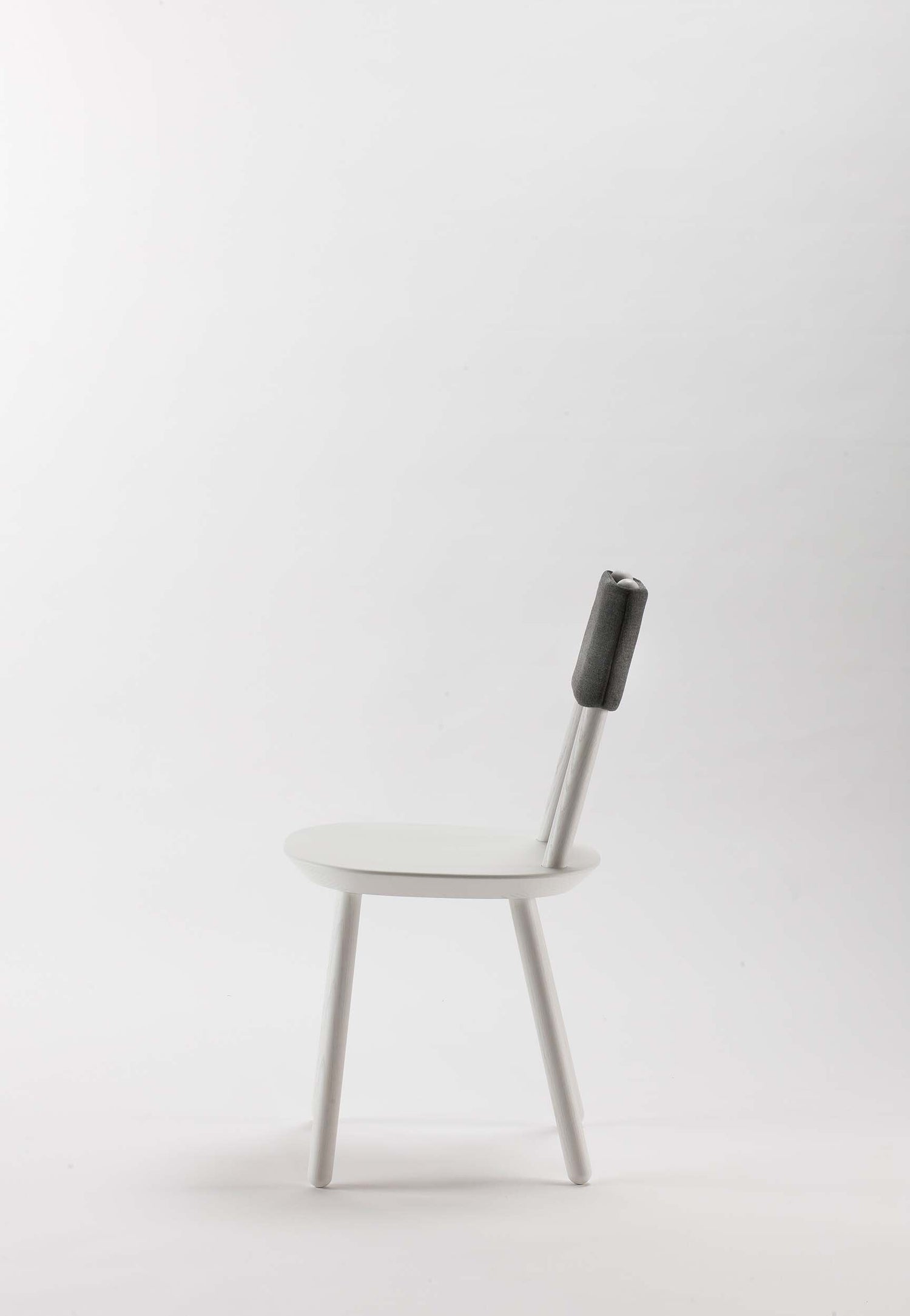 White Naïve Dining Chair by Aquamarine Poppy with sleek modern design and smooth wooden legs.