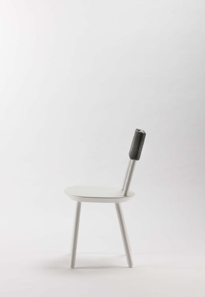 White Naïve Dining Chair by Aquamarine Poppy with sleek modern design and smooth wooden legs.