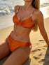 Pear Daisy orange bikini split swimsuit with sunken stripe texture, designed for a sexy, stylish beach look.