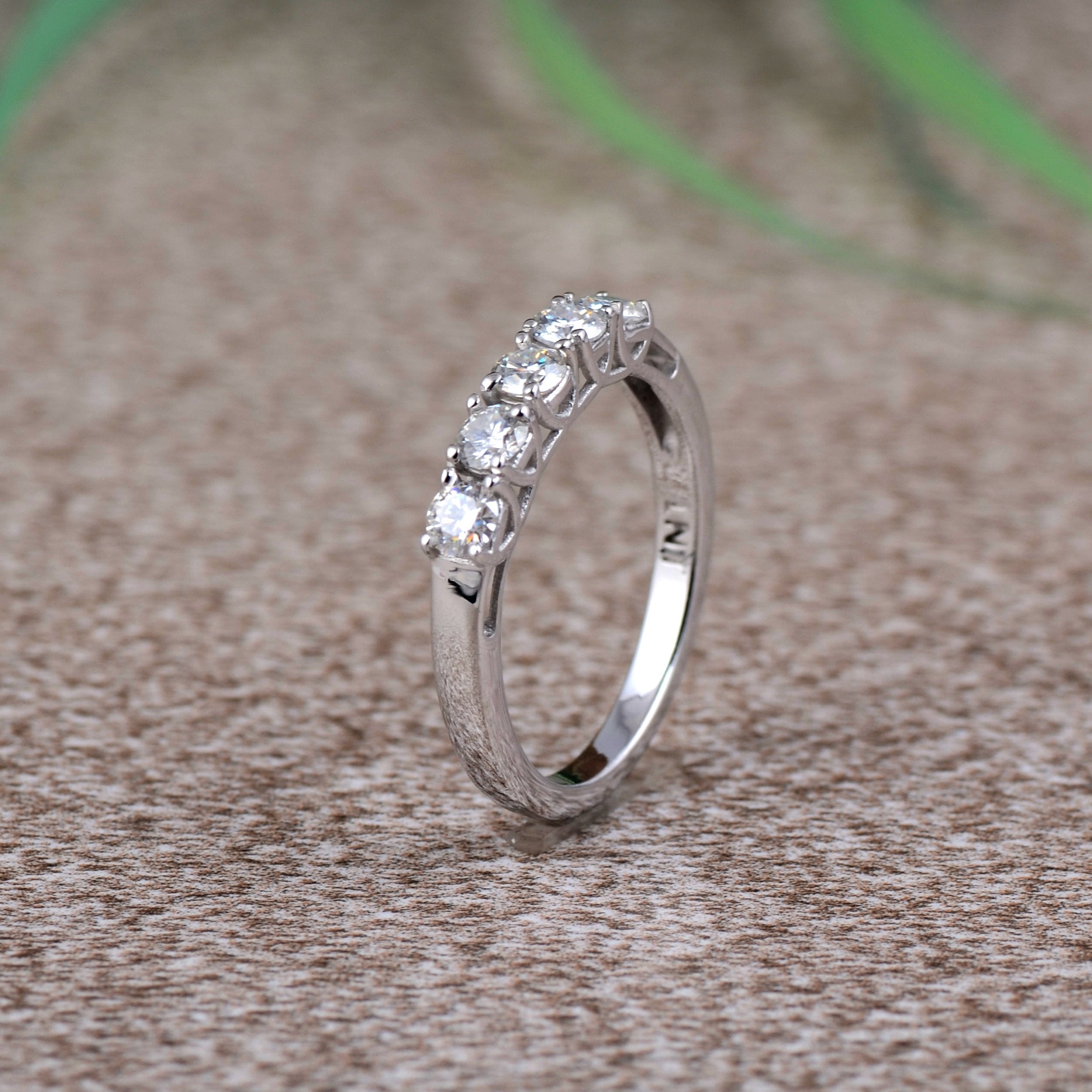 Sterling silver white moissanite 5-stone ring with sparkling gemstones, elegant jewelry piece by Copper Juniper.