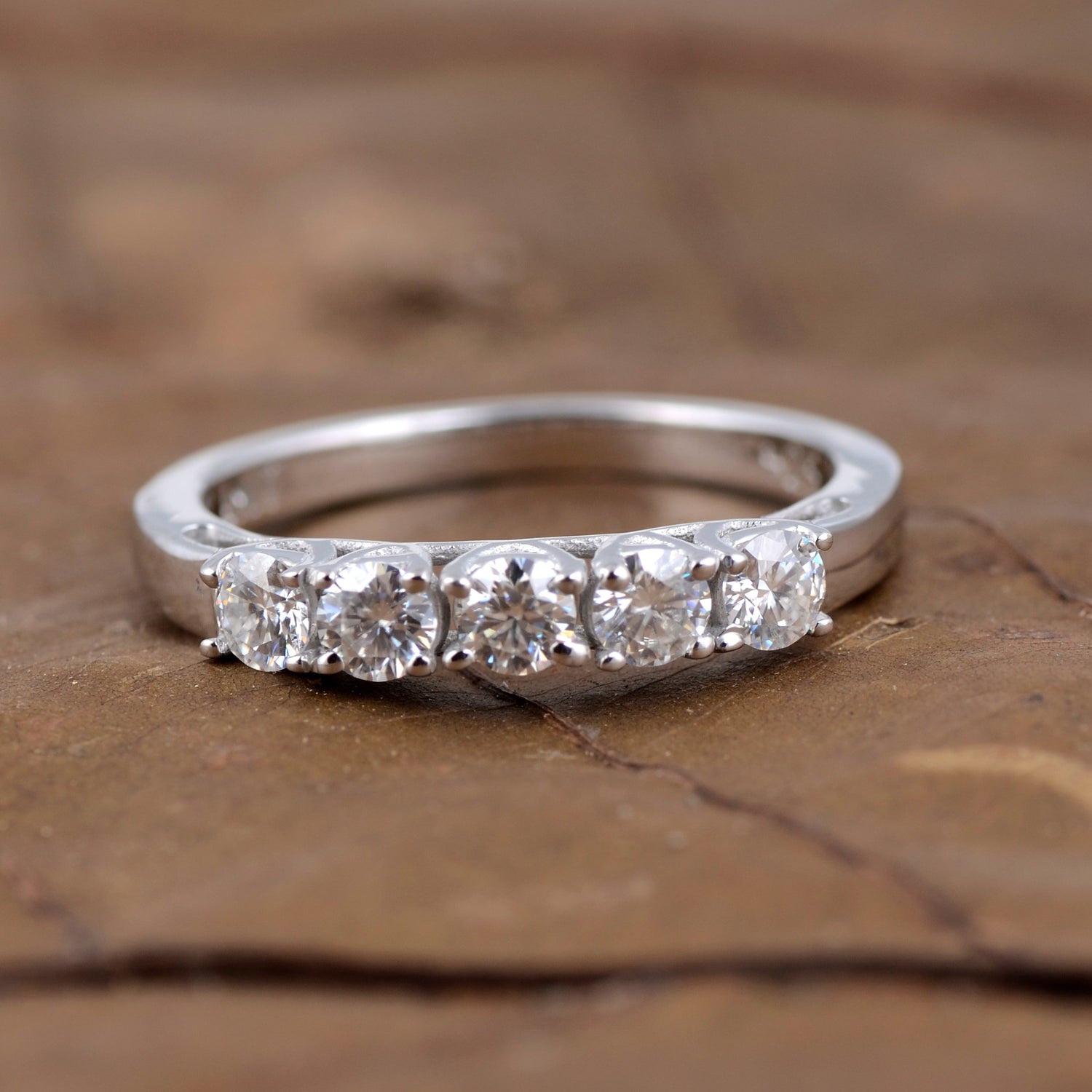 Sterling silver white moissanite 5-stone ring featuring sparkling gemstones and elegant band design.