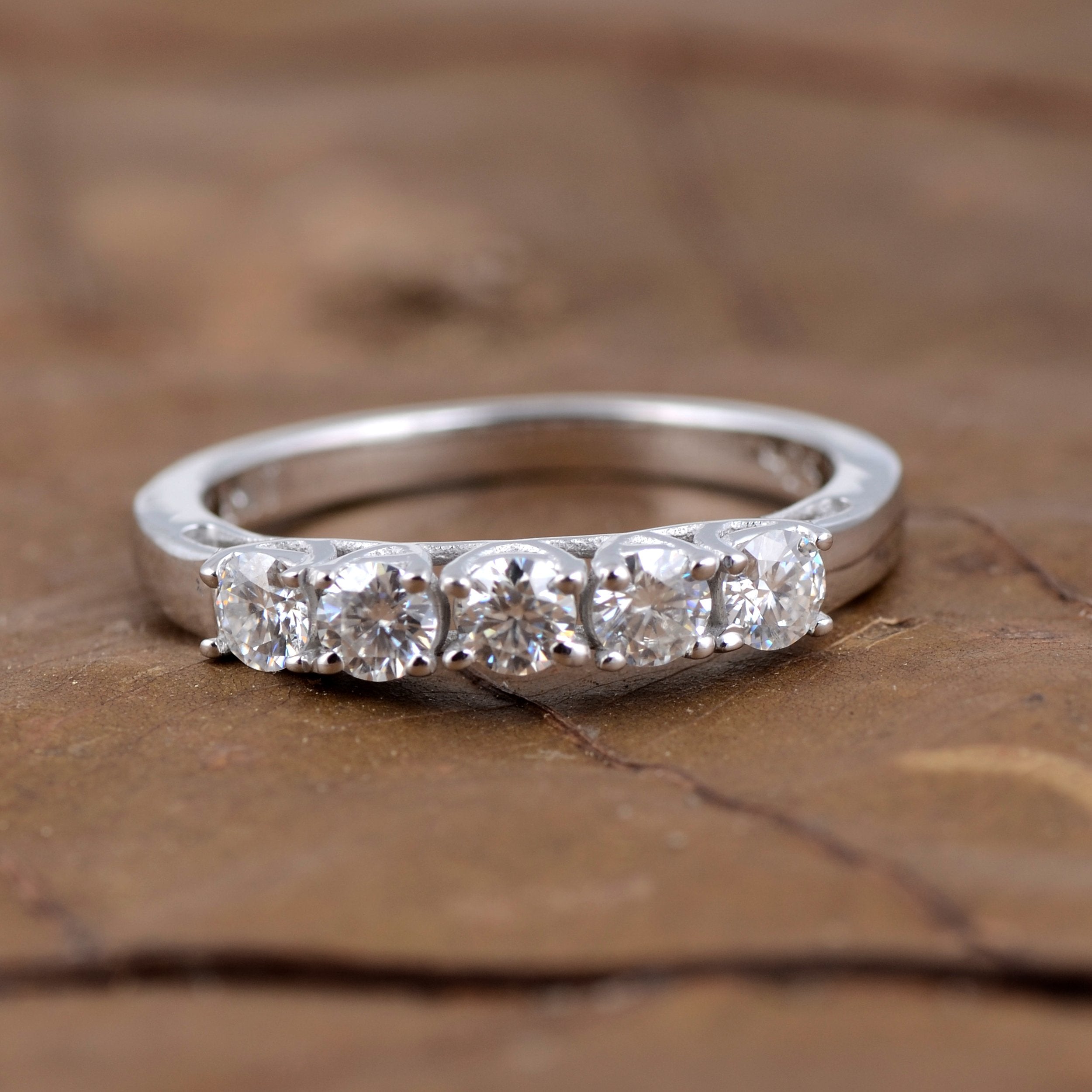 Sterling silver white moissanite 5-stone ring featuring sparkling gemstones and elegant band design.