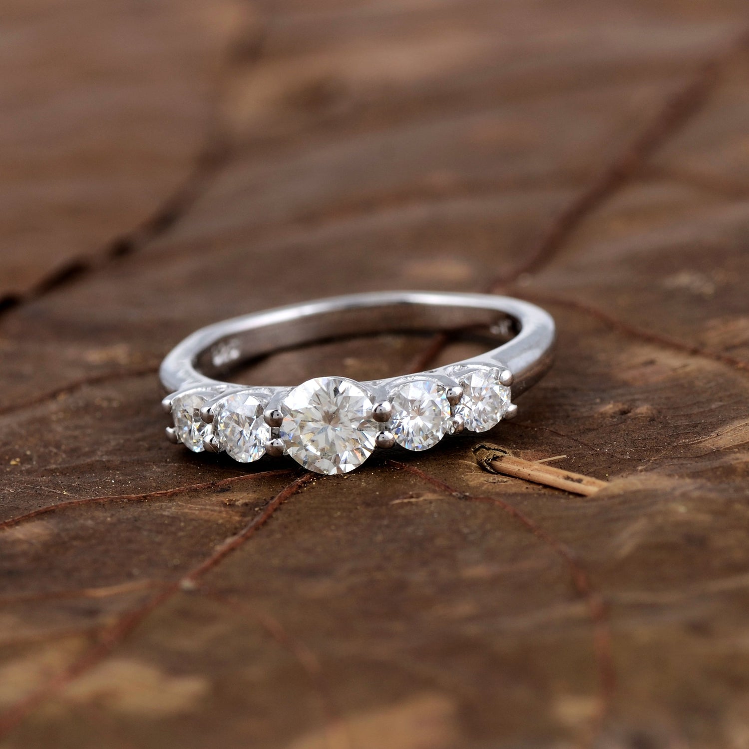 Sterling silver white moissanite 5-stone ring featuring sparkling gemstones, elegant jewelry piece from Copper Juniper.