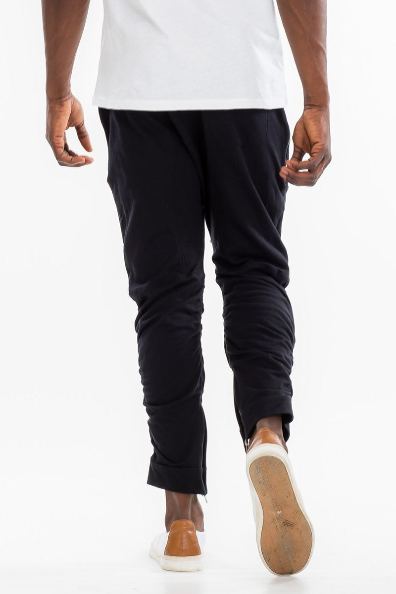 Black gathered bomber pants by Lime Milo featuring a relaxed fit and elastic waistband, displayed on a hanger.