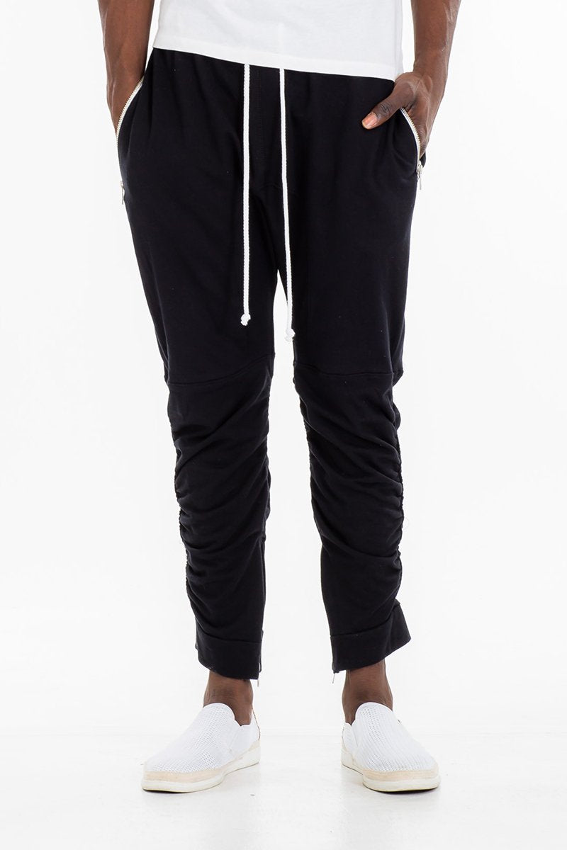 Black gathered bomber pants by Lime Milo, showing the relaxed fit and elastic waist design with side pockets.