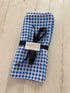 Blue Vichy patterned paper napkins by Sky Gaia for home decor, displayed in a neatly folded stack.