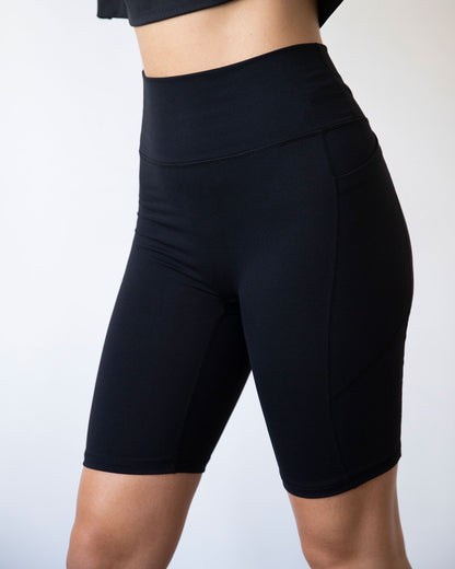 Black Making Moves Pocket Biker Shorts for women by Lemon Molly, showing side view with pockets and 8.5-inch length.