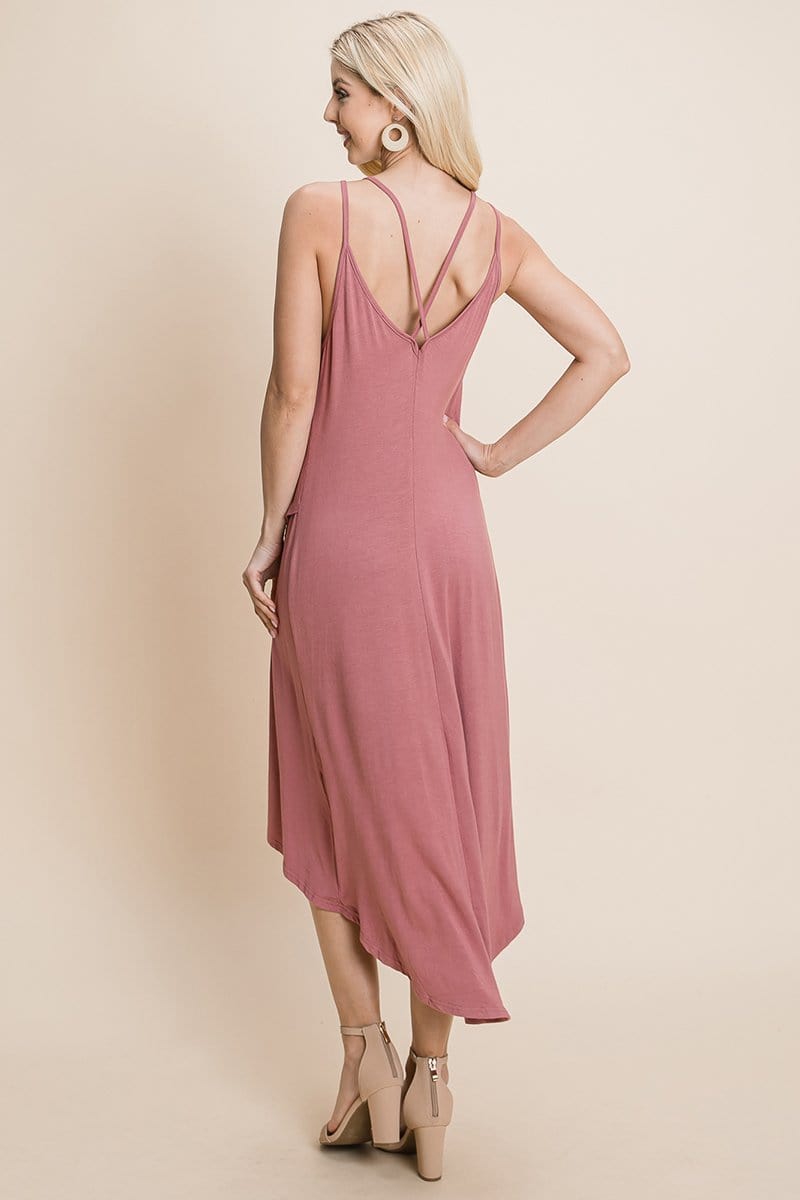 Dusty pink deep V cami casual dress with high-low hem and crisscrossing straps by Aquamarine Gaia, styled for a relaxed look.