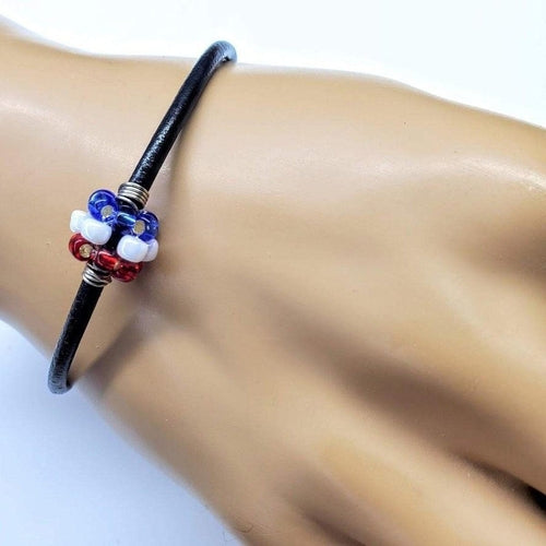 Red, white, and blue beaded leather bracelet by Blue Crius featuring colorful beads and adjustable leather strap.