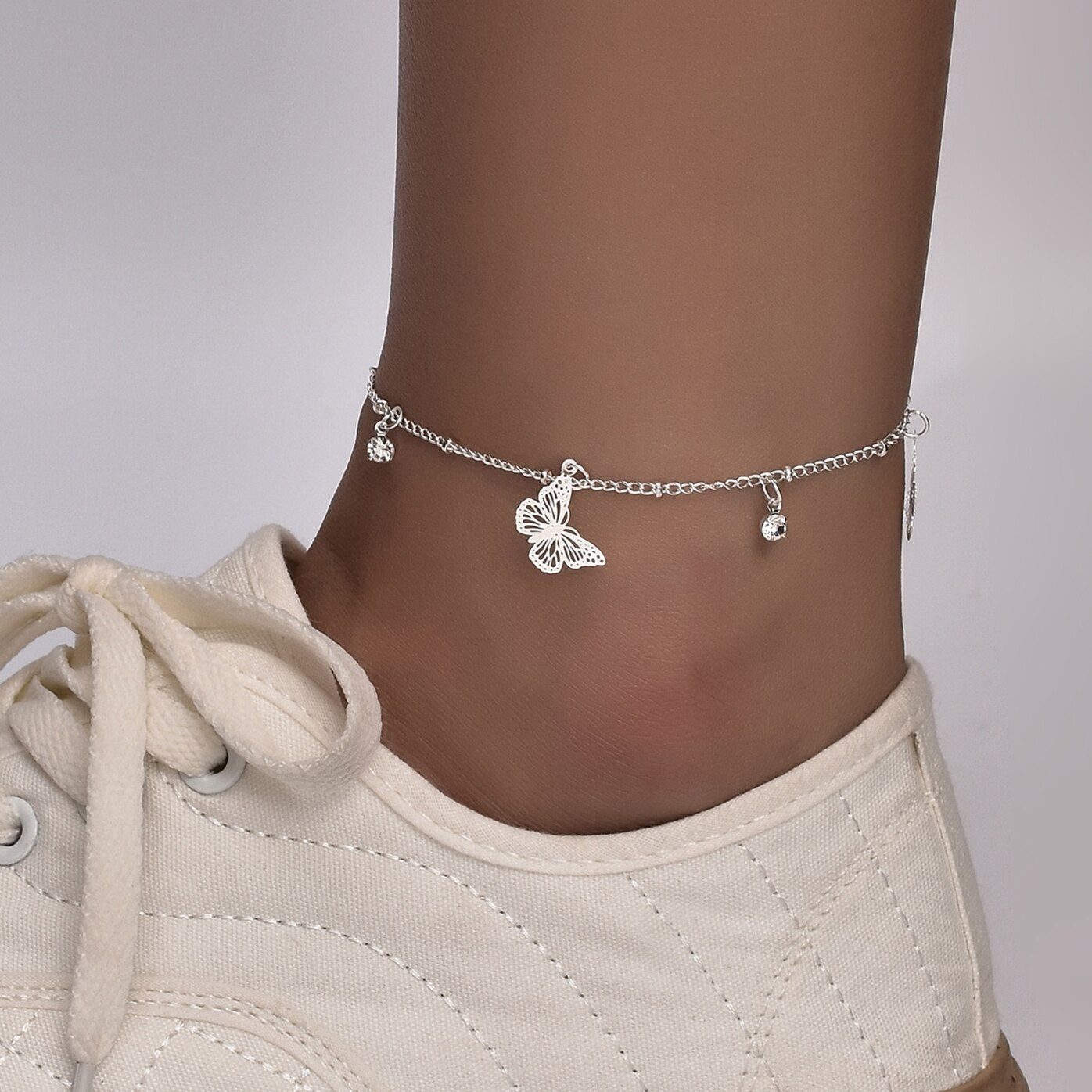 Silver plated Butterfly Bohemia ankle bracelet by Red Iphigenia featuring delicate chain design and butterfly charms.