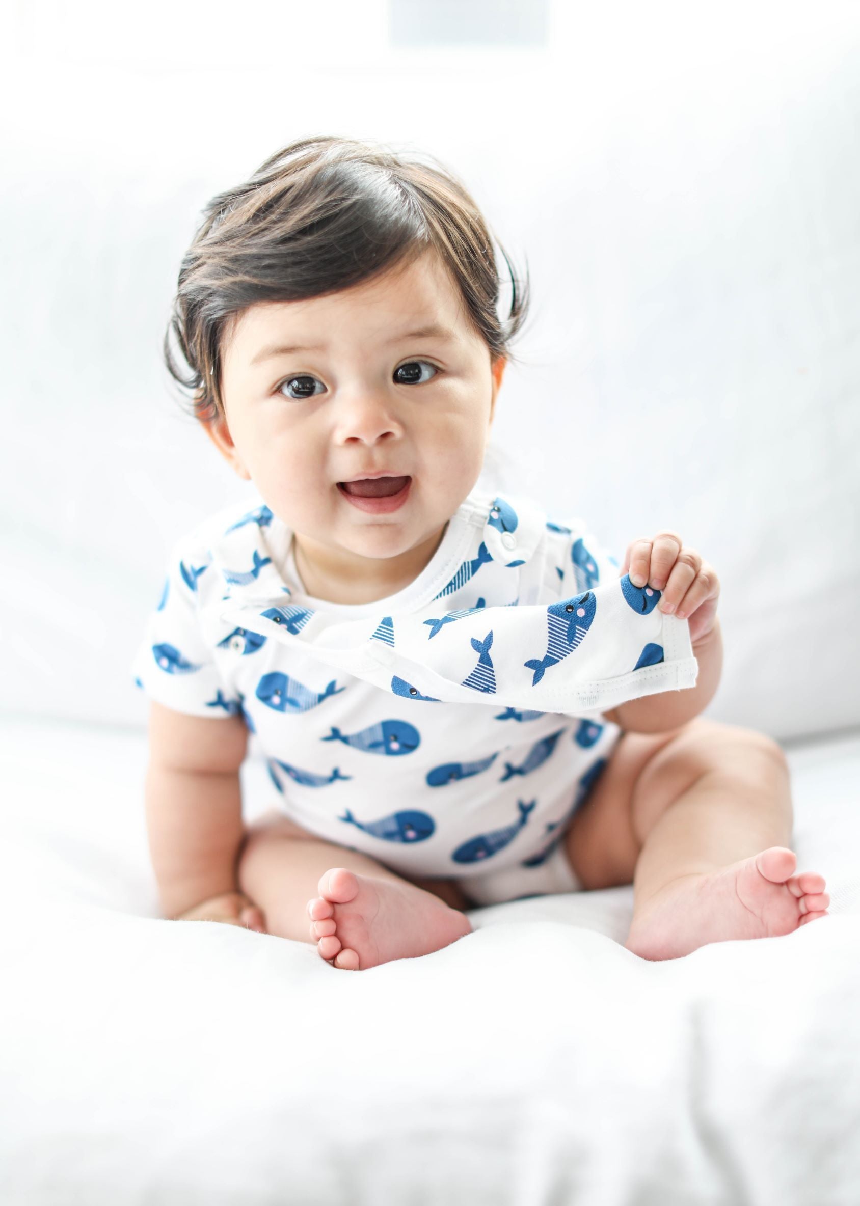Blue whale print baby bodysuit and bib set from Fuchsia Milo, featuring short sleeves and soft, comfortable fabric.