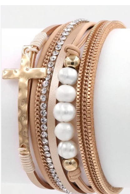 Multi-layer magnetic bracelet with cross and pearl accents by Ochre Ismene, featuring layered design and decorative charms.