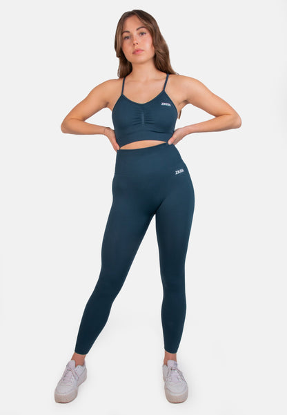 Dark teal seamless sports bra from Pear Juniper, styled with matching leggings for activewear or casual outfit.