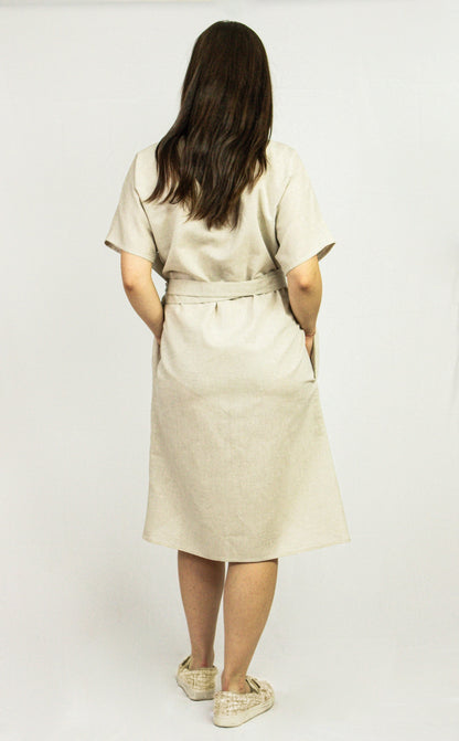 Light beige Natural Light linen wrap dress by Magenta Sugarplum, featuring a fitted waist and flowing fabric.