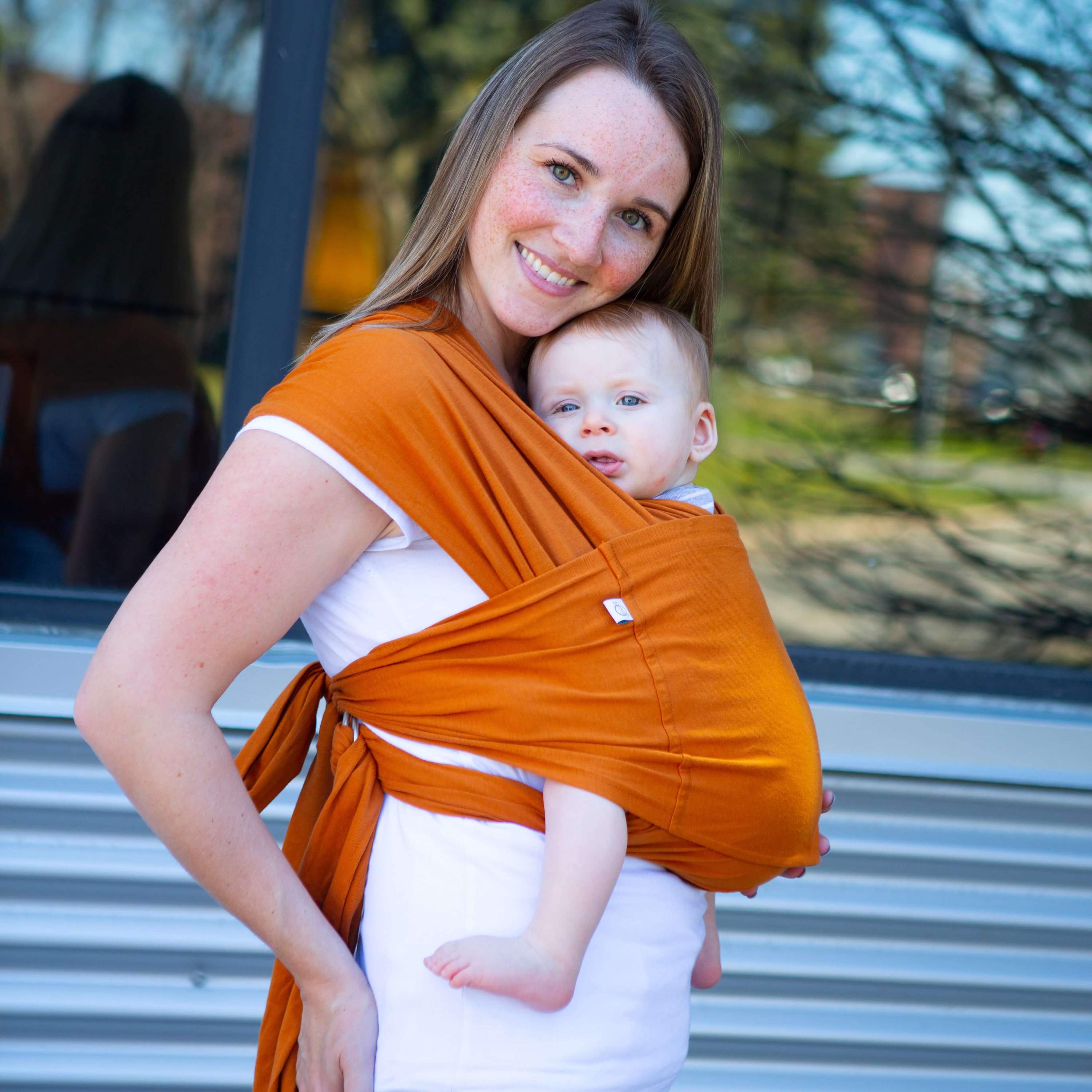 Amber Leto Snüg baby clothing featuring a cozy golden oak-patterned snuggly outfit for infants.