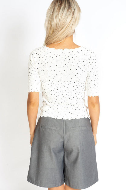 White polka dot top with ruffled frill details from Azure Thanatos, stylish blouse perfect for casual or dressy occasions.