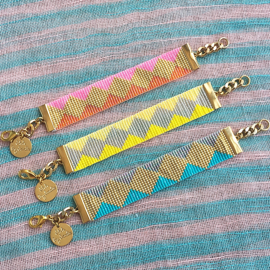 Yellow Athena Soleil bracelets featuring colorful beaded designs on a display, showcasing vibrant, stylish jewelry accessories.