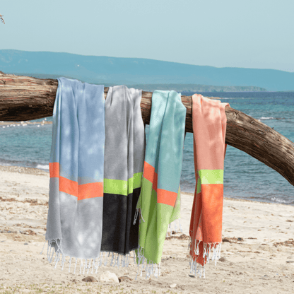 Neon mint and lime 2-in-1 hammam towel and bag made from recycled cotton by Copper Amymone, displayed folded with vibrant colors.