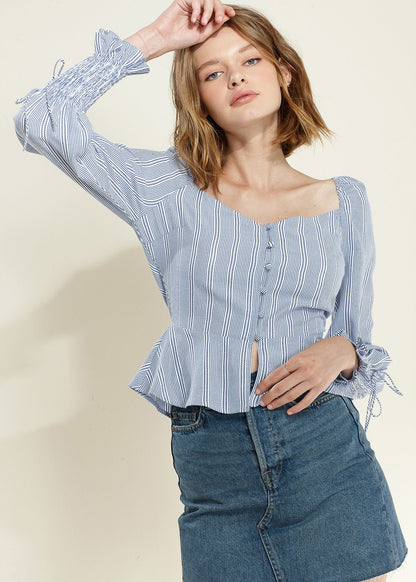 Blue smocked cuff button-front peplum blouse by Lemon Hera, featuring long sleeves and a stylish, feminine design.