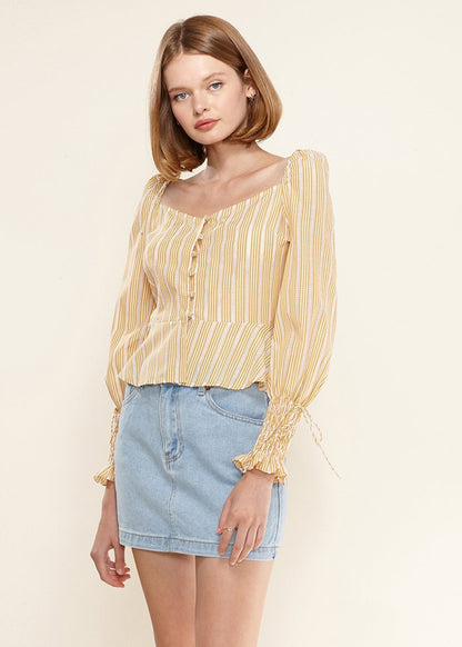 Yellow smocked cuff button-front peplum blouse by Lemon Hera, showing the stylish top with a fitted waist and decorative cuffs.