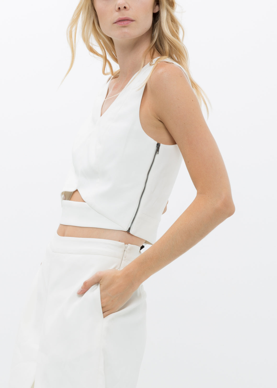 White V-neck sleeveless cropped top by Lemon Hera, shown on a hanger with smooth fabric and clean design details.