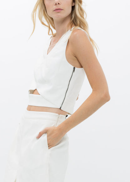 White V-neck sleeveless cropped top by Lemon Hera, shown on a hanger with smooth fabric and clean design details.