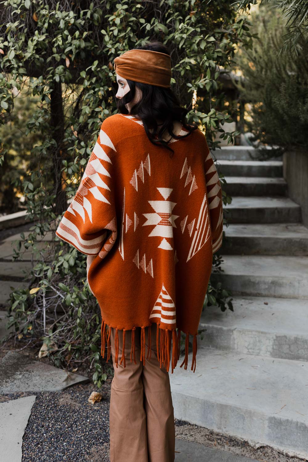 Periwinkle Aether Aztec Luxe fringed ruana draped over a model, showcasing its intricate patterns and cozy accessory style.