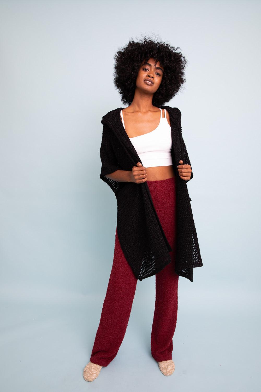 Black cozy soft waffle hooded ruana from Periwinkle Aether, featuring a relaxed fit and textured fabric for warmth and comfort.