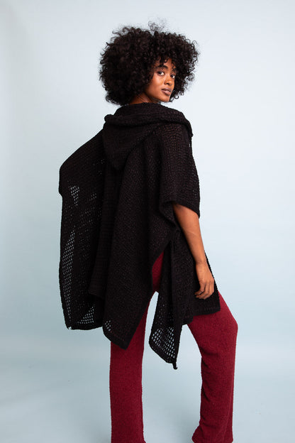 Black cozy soft waffle hooded ruana by Periwinkle Aether, featuring a warm, textured fabric with a hood and relaxed fit.