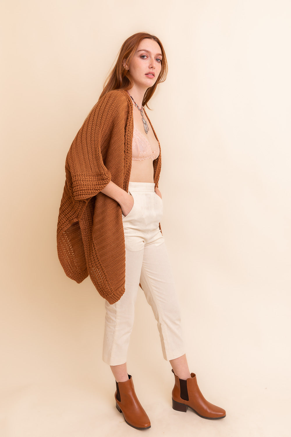 Camel-colored rib knit ruana by Periwinkle Aether, stylish layered wrap with textured ridged pattern for cozy elegance.
